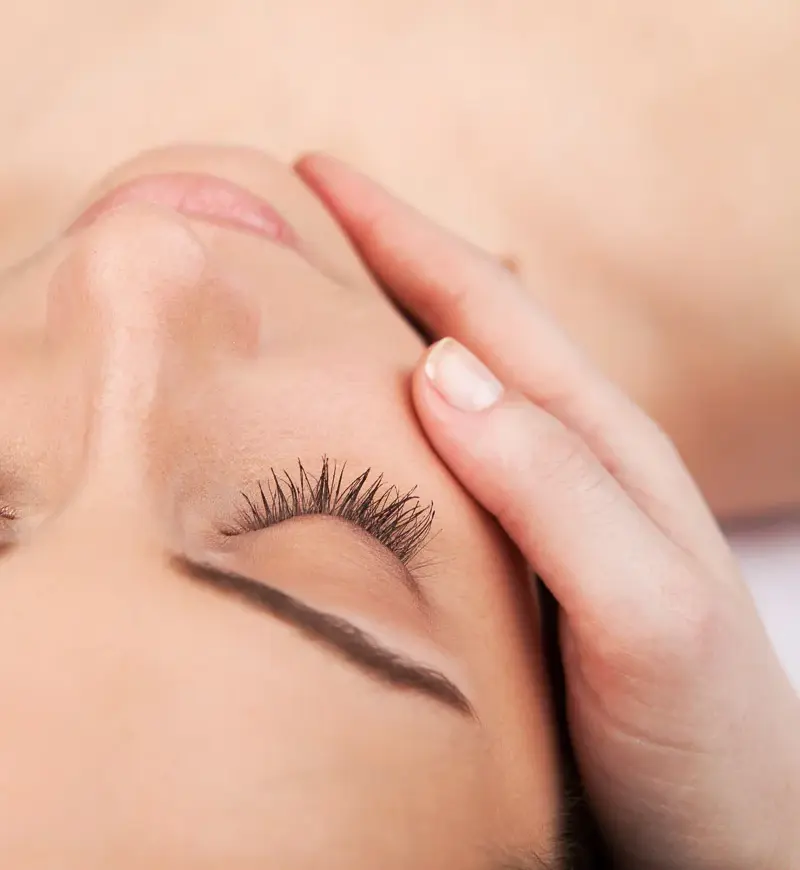 Woman receiving relaxing facial massage treatment at Beauty Refined